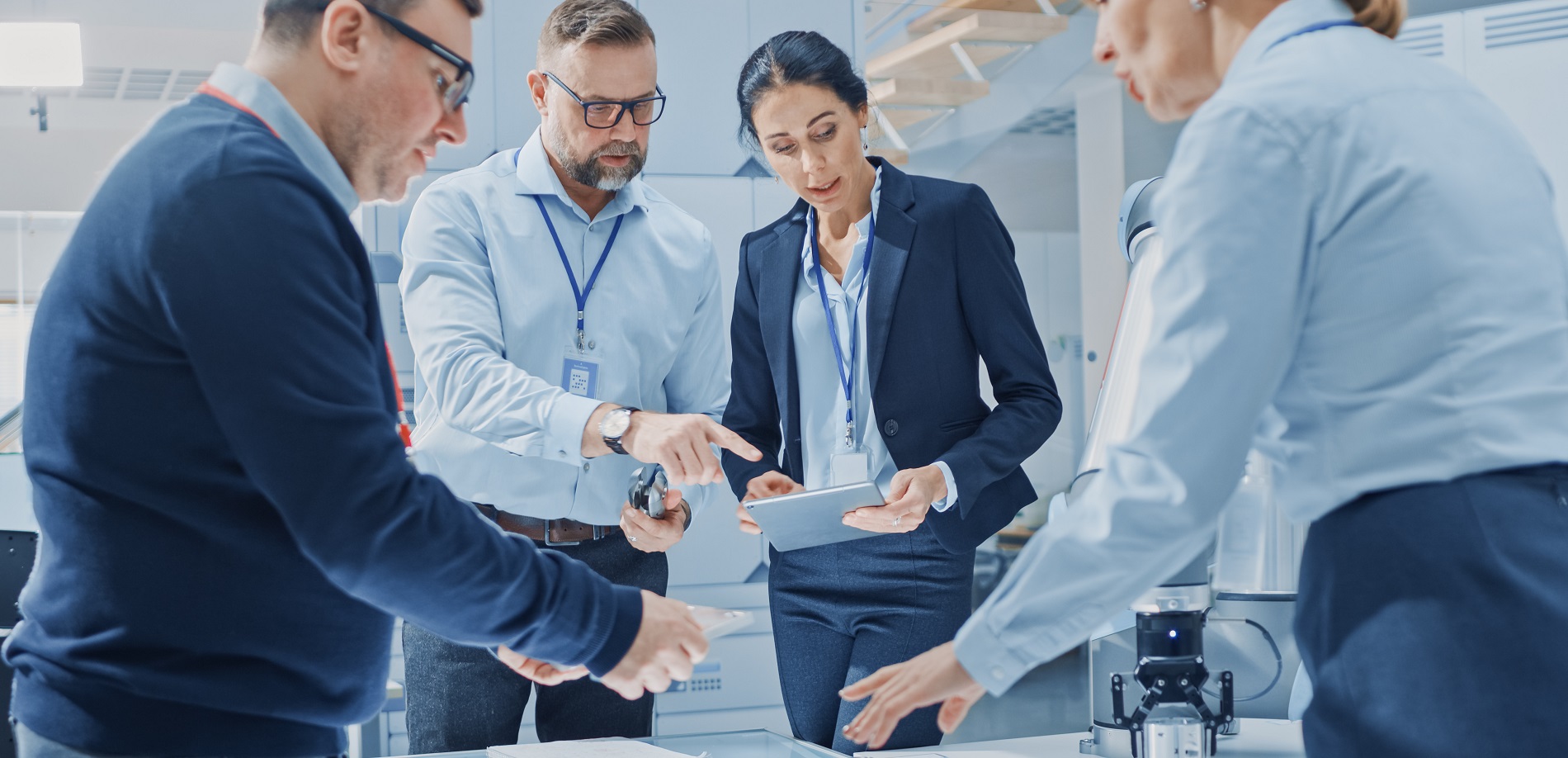 Mehrere Personen unterhalten sich und schauen auf ein Tablet