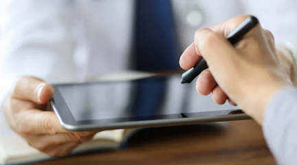 Eine Hand hält einen Stift für eine elektronische Unterschrift auf einem Tablet