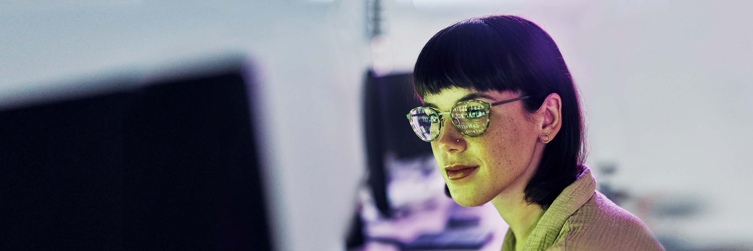 Eine Frau mit Brille schaut auf einen Monitor