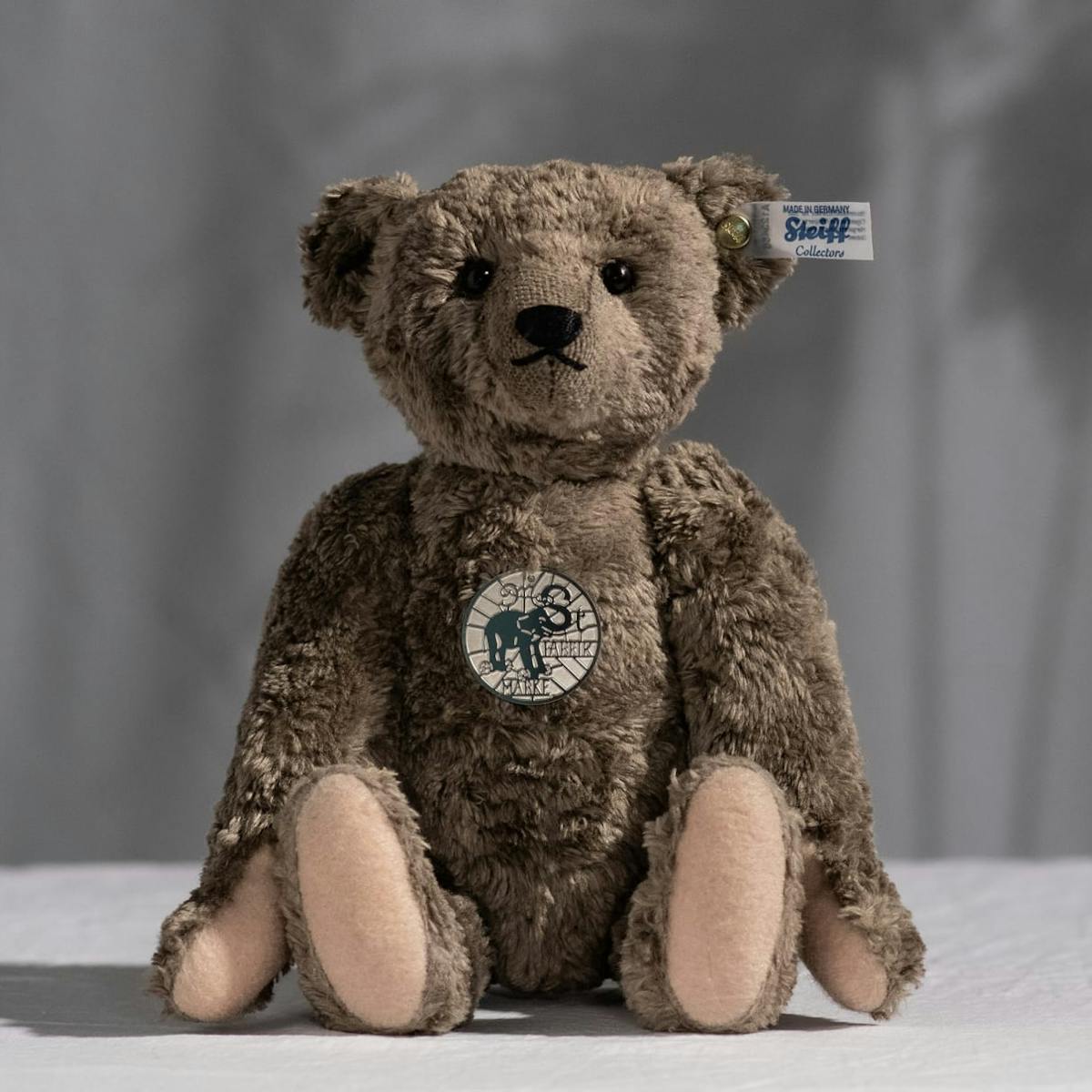 Ein Teddybär von Steiff sitzt auf dem Boden